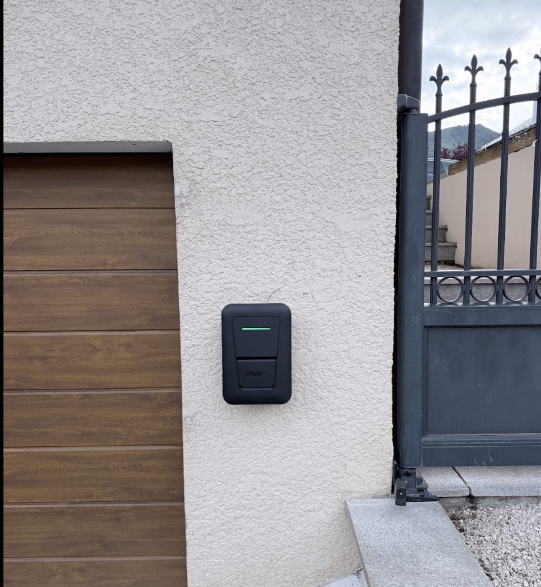 Borne de recharge murale installée à côté d'une porte de garage
